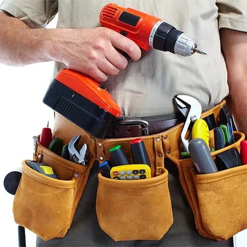 Installation technician with a drill and hand tools
